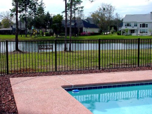 Black aluminum fence surrounding swimming pool