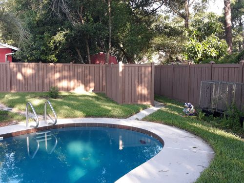 Pool area surrounded by privacy wood fence